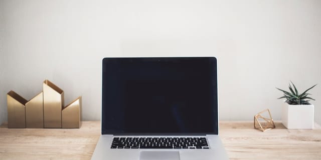 MacBook Pro on top of brown table