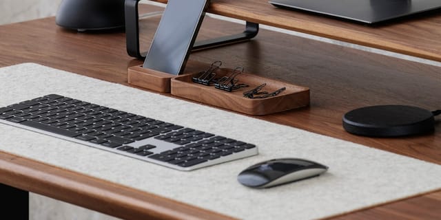 A modern smartphone on a desk with a code editor open, displaying an AI agent interface.