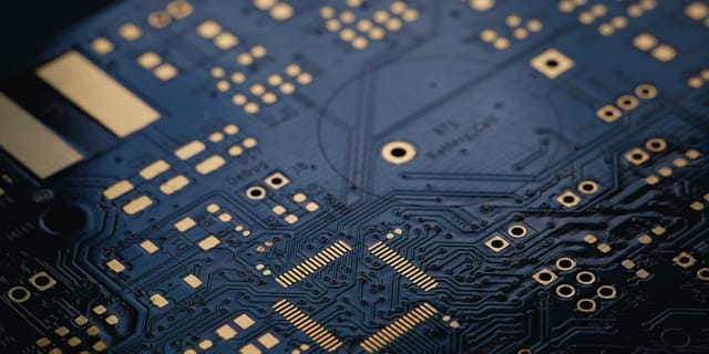 Close-up macro photography of a modern blue server circuit board with visible processor chips and copper traces.