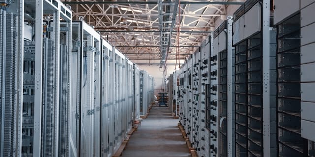 GPU server racks in a dim data center with cooling fans spinning