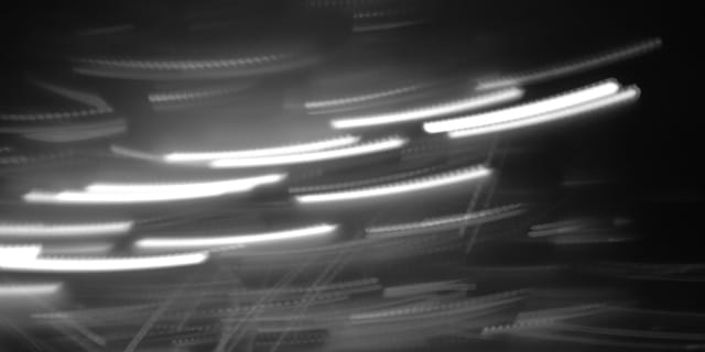Motion blur of light streaks on a dark background suggesting high speed