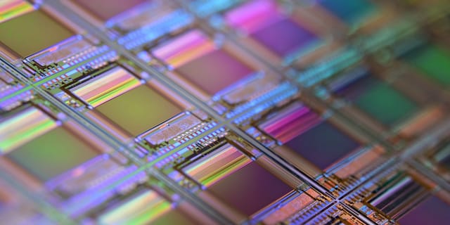 Close-up of a server processor chip with visible die and pins on a dark circuit board.
