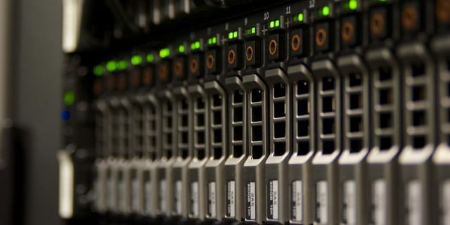 Rows of server racks in a dimly lit data center aisle