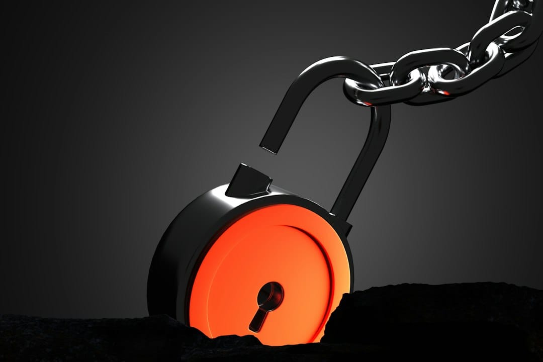 A 3D render of an open padlock with a glowing orange core attached to a metal chain.