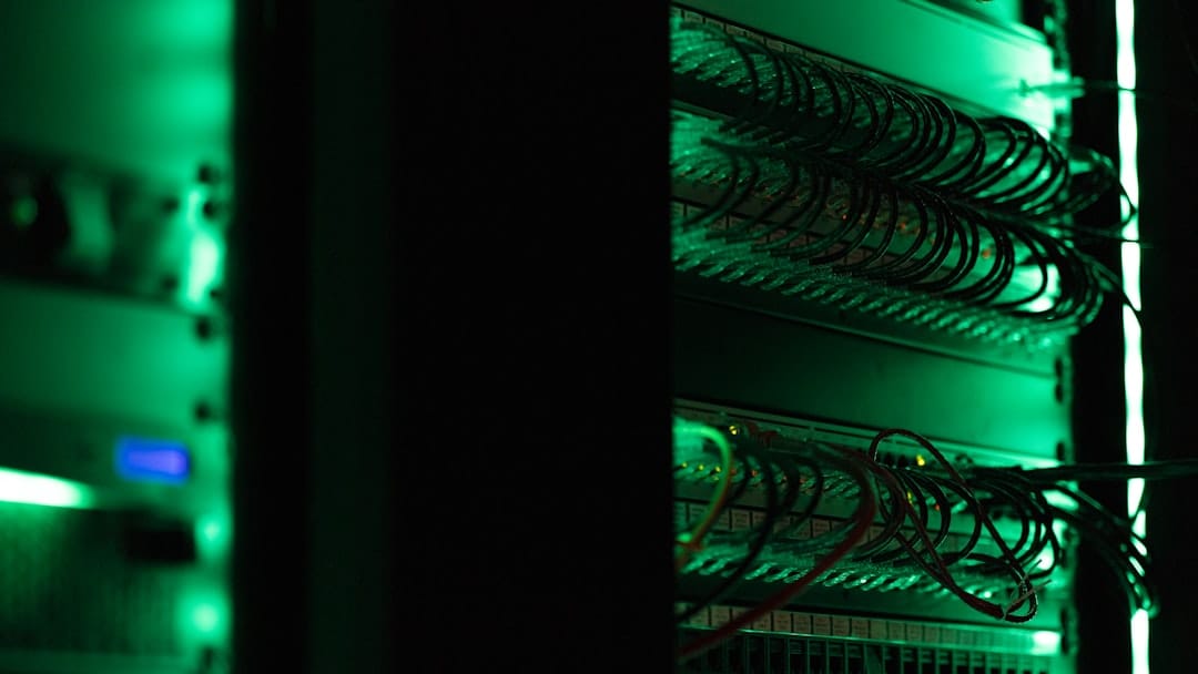 A rack of electronic equipment in a dark data center room, lit by indicator LEDs — the kind of infrastructure serving the DeepSeek V4 Flash API